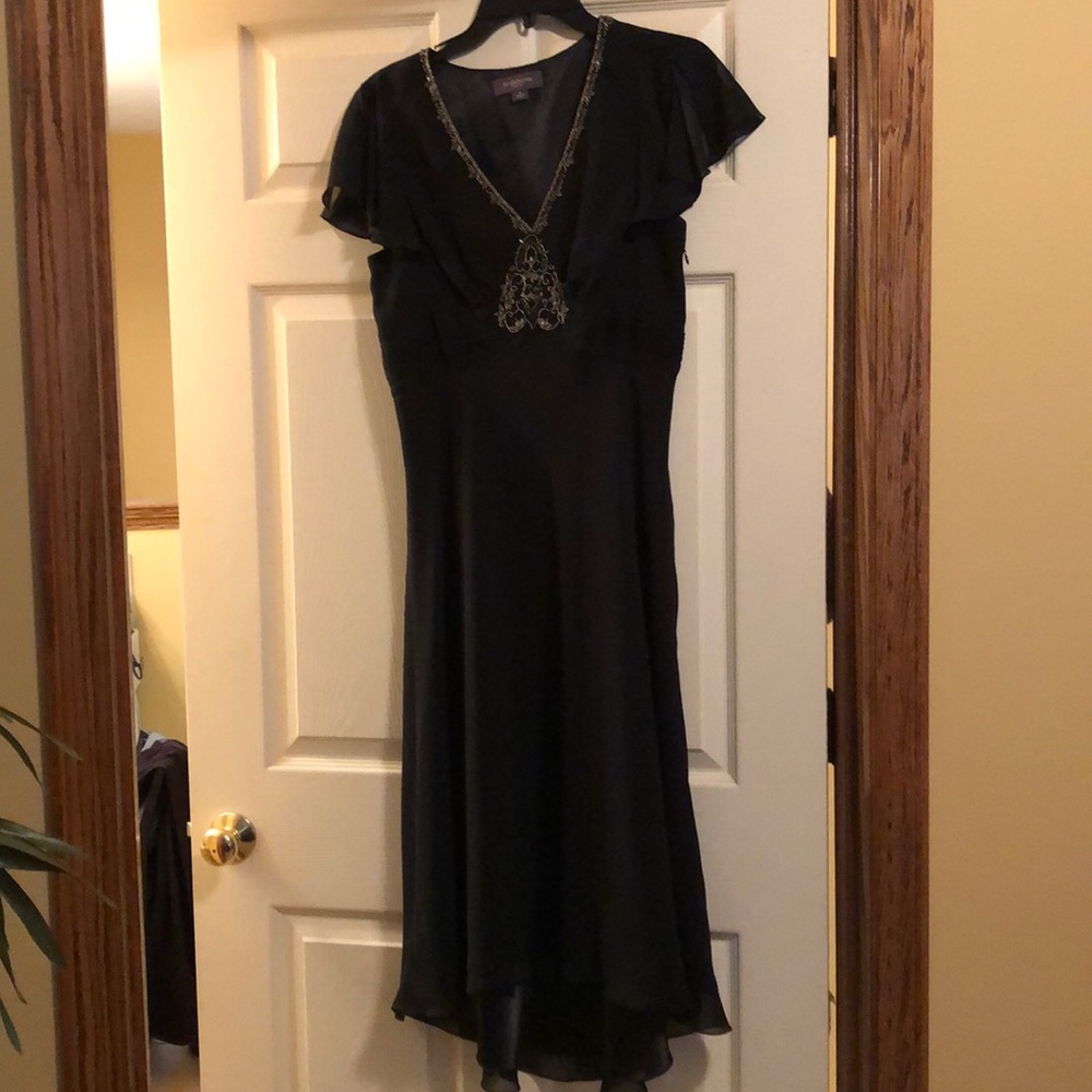 Timeless black dress with gold trim appliqué .